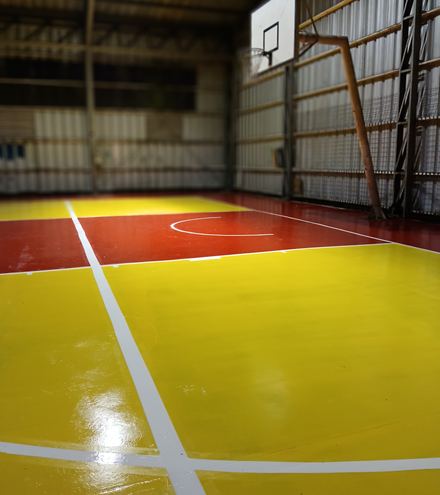 El mismo gimnasio con el piso terminado en amarillo, rojo y líneas blancas