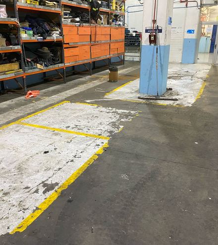 Piso de taller con pintura desprendida y demarcación gastada