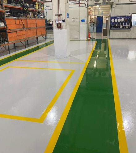 El mismo taller con piso gris, pasillo verde y demarcación amarilla nueva